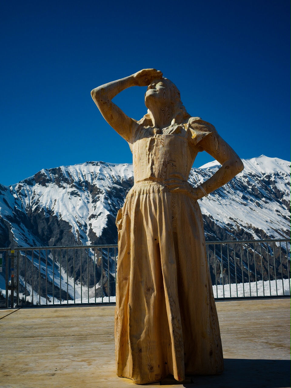 STATUE ON SNOW COVERED MOUNTAIN AGAINST CLEAR SKY