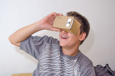 Boy watching virtual reality against white background