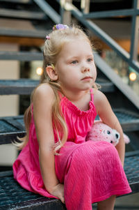 Portrait of cute girl sitting on staircase