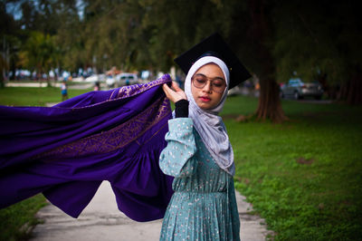 Portrait of man wearing hat standing against trees