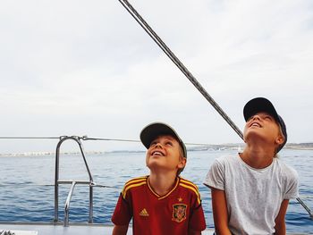 Happy friends against sea against sky