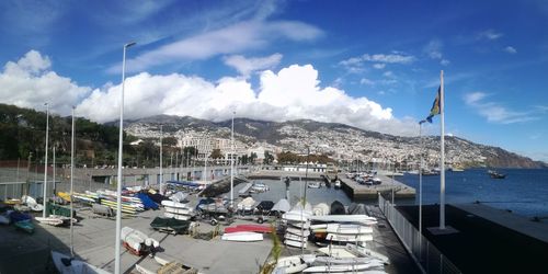 Boats moored at harbor against sky