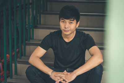 Portrait of young man sitting on steps