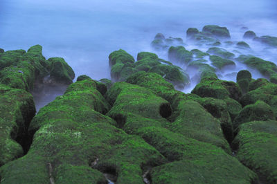 Scenic view of rocks in sea against sky