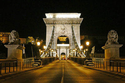 Statue of illuminated bridge at night