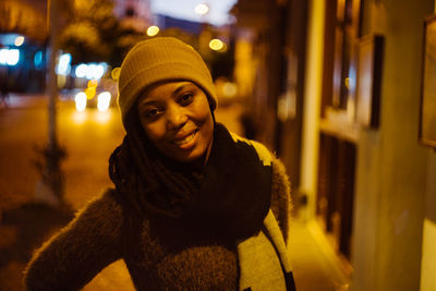 Portrait of smiling woman in illuminated city at night