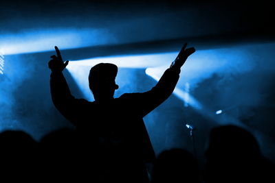 Silhouette man dancing at music concert