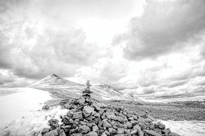 People on rock against sky