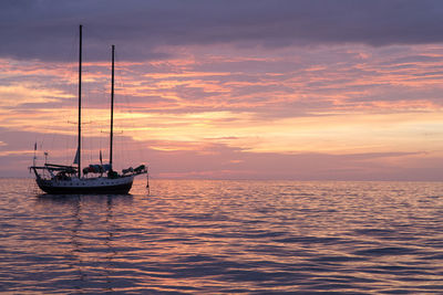 Boats in sea at sunset