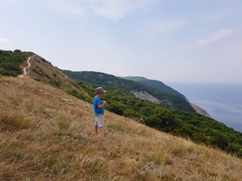 Rear view of man on mountain against sky