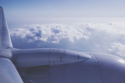 Cropped image of airplane flying over cloudscape