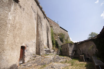 Man walking on old wall against clear sky