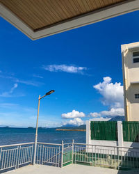 Seagull by railing against blue sky