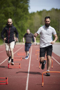 Men participating in sports competition on athletics track