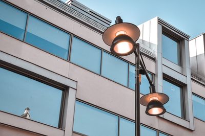 Low angle view of illuminated street light against building