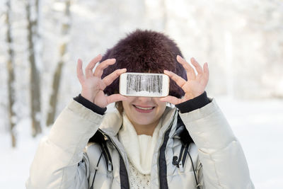 Portrait of young woman photographing with smart phone