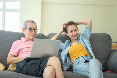 Young man using mobile phone while sitting on sofa