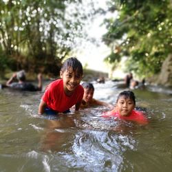 Portrait of smiling siblings in river