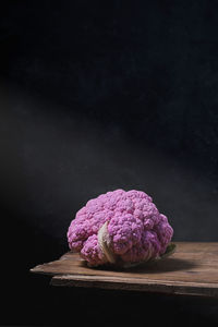 Close-up of pink flowers on table against black background