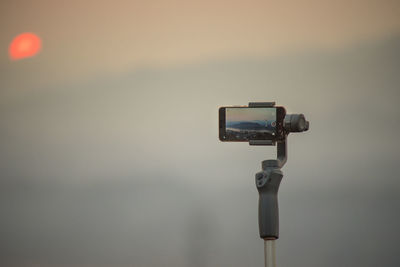 Close-up of camera against sky