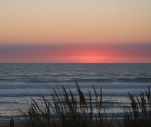 Scenic view of sea against romantic sky at sunset