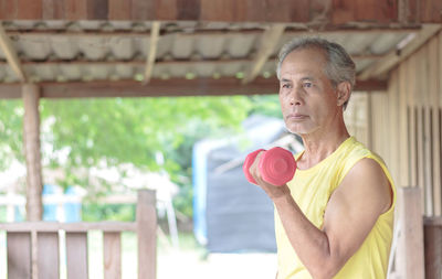 Man holding camera while standing outdoors