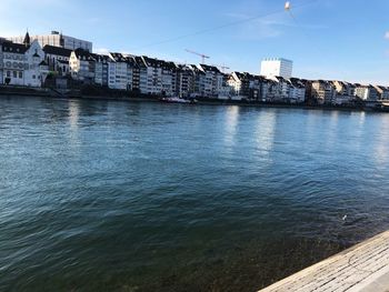 Buildings by sea against sky