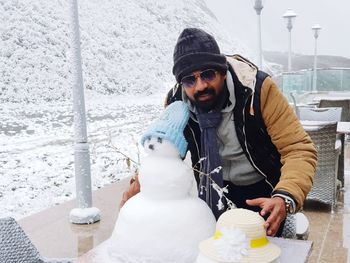 Full length of woman sitting in snow