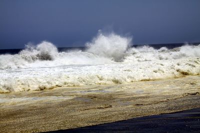 Scenic view of sea waves against clear sky