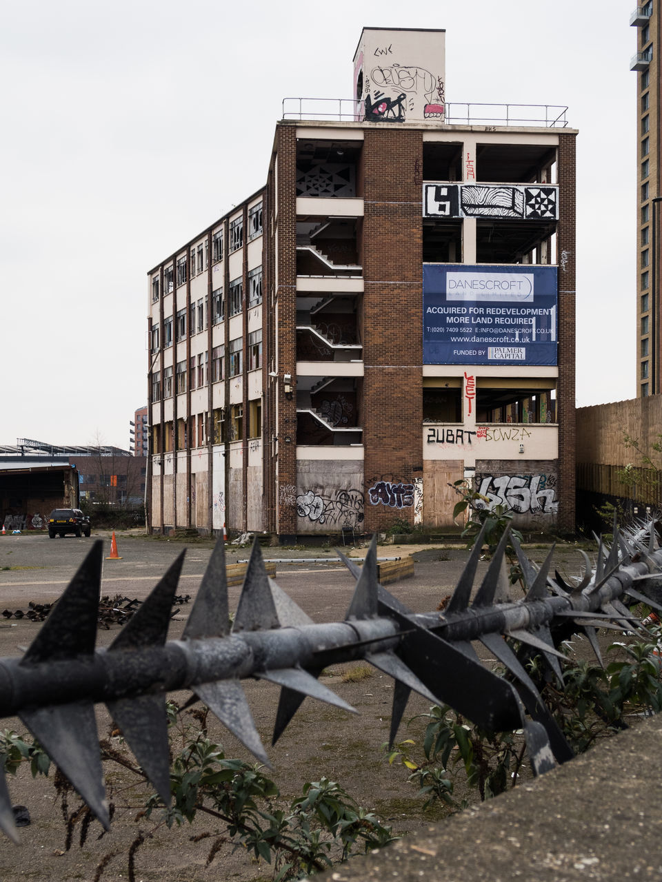 built structure, architecture, building exterior, text, abandoned, metal, western script, clear sky, obsolete, damaged, old, day, run-down, communication, sky, outdoors, rusty, no people, deterioration, sunlight