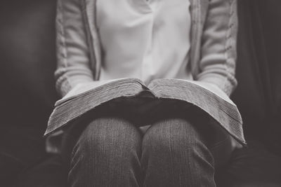 Midsection of woman holding book