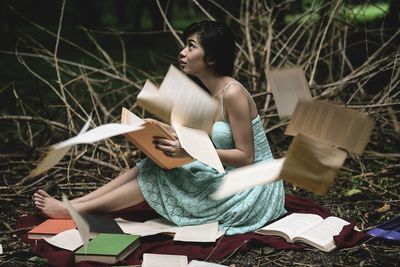 Woman sitting amid scattered books