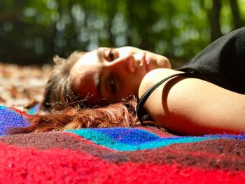 Close-up portrait of woman lying on field