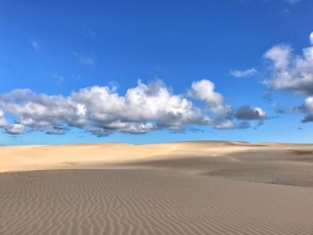 Scenic view of desert against blue sky
