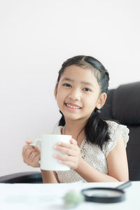 Portrait of a smiling young woman holding drink