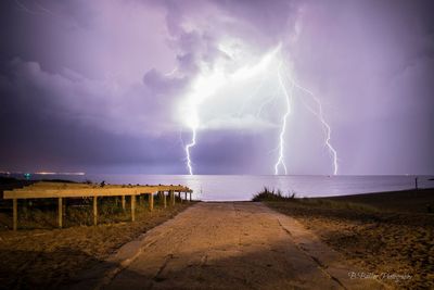 Lightning over sea against storm clouds