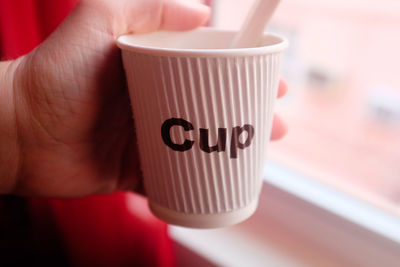 Close-up of hand holding coffee cup