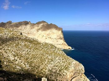 Rock formations in sea against blue sky