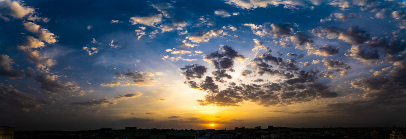 Panoramic view of silhouette buildings against sky during sunset