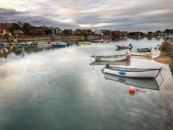 High angle view of boats moored in river against cloudy sky