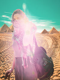 Midsection of woman standing on field against sky