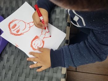 High angle view of man holding paper on table