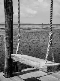 View of wooden post in sea against sky