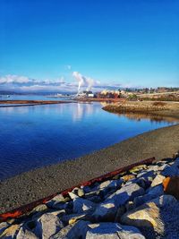 Scenic view of river against blue sky