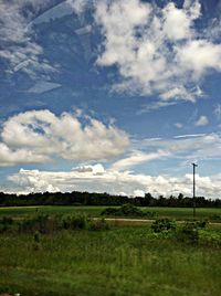 Scenic view of grassy field against cloudy sky