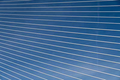 Low angle view of blue sky seen through fence