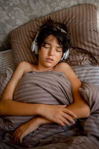 Portrait of young woman lying on bed at home