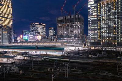 Modern buildings in city against sky at night