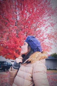 Midsection of woman standing by tree during winter