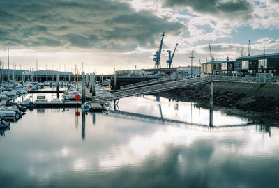 Boats moored at harbor during sunset